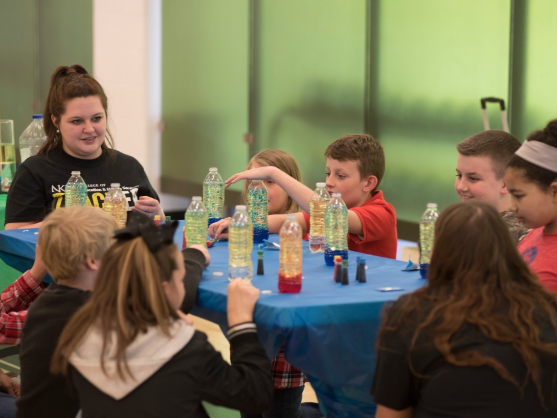 4th grade students enjoying a hands-on STEM activity with a Northern Kentucky University pre-service teacher at Elementary STEM Day event