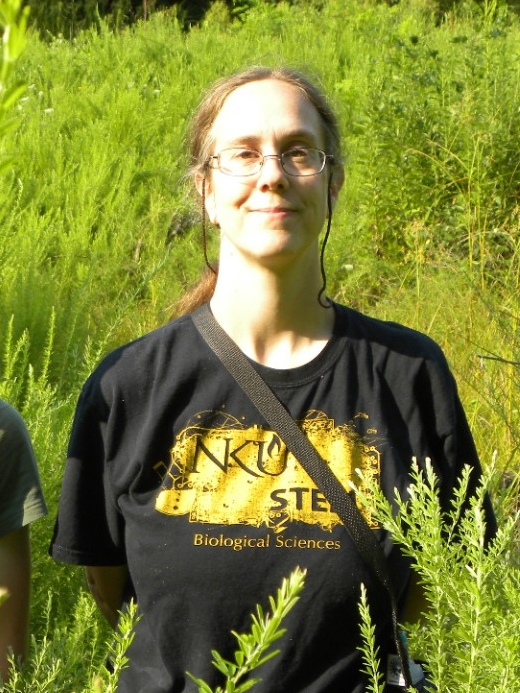 Dr. Whitson smiles outside in a field.