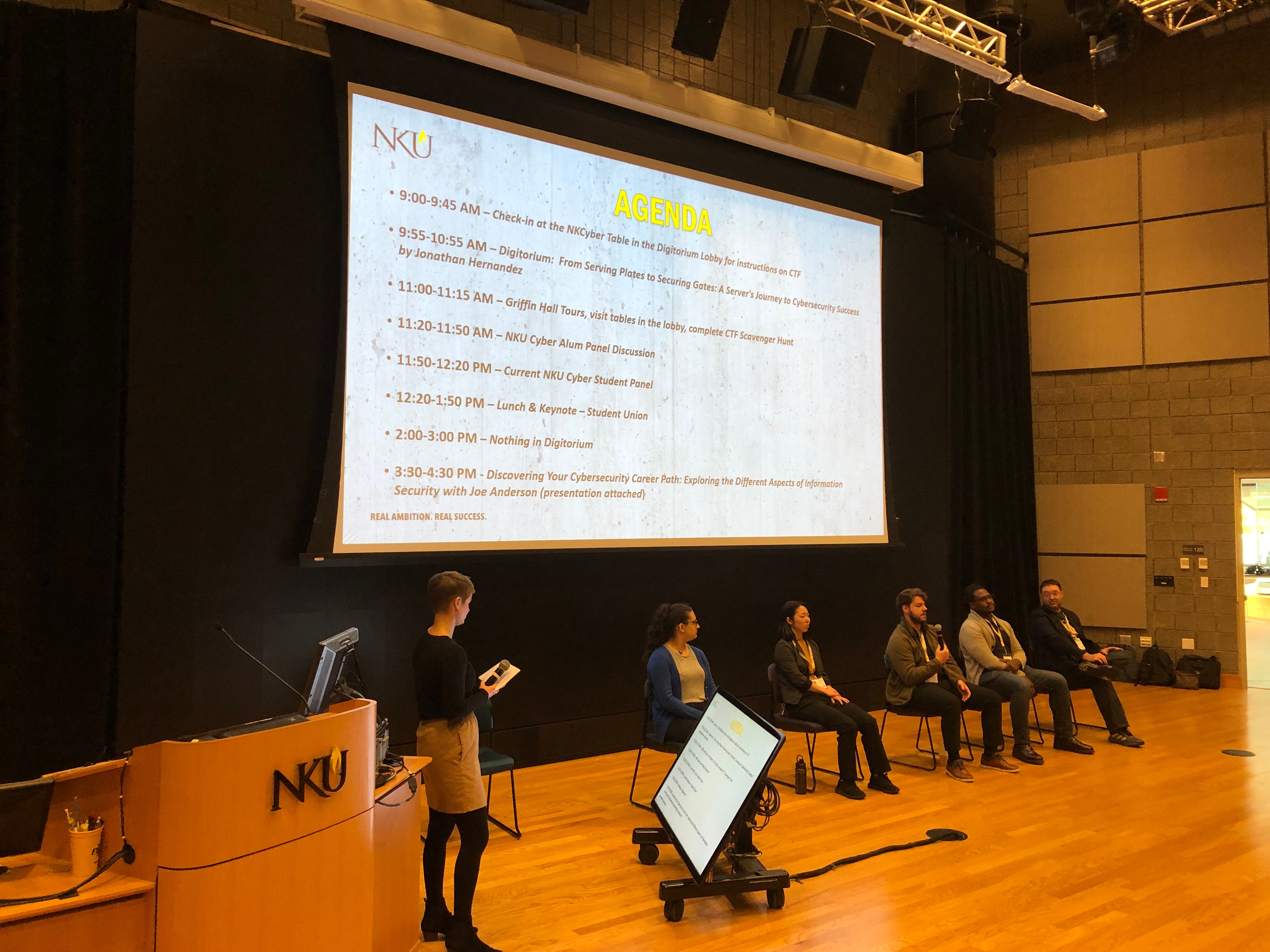 Alumni sitting speaking into microphone in the Griffin Hall Digitorium