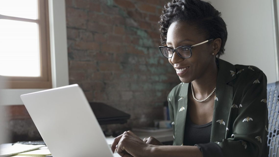 Woman sitting at a laptop taking an online class