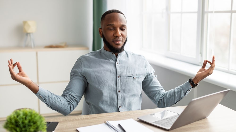 Man sitting at a desk meditating